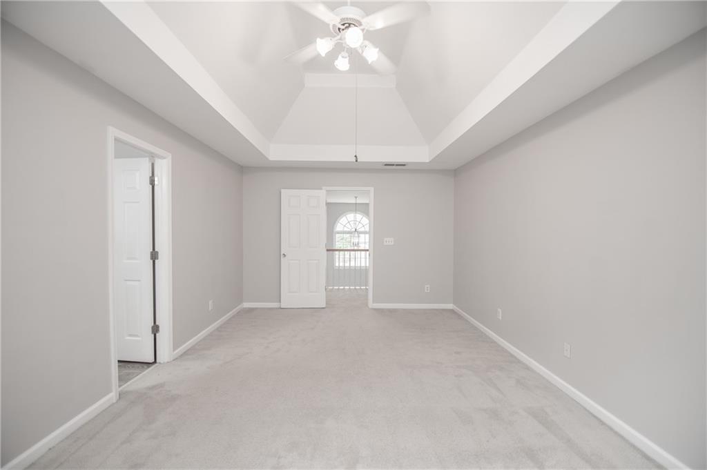 755 Sheridan Ridge Court Alpharetta, GA 30022 - Photo 28 of 57 an empty room with chandelier fan and windows