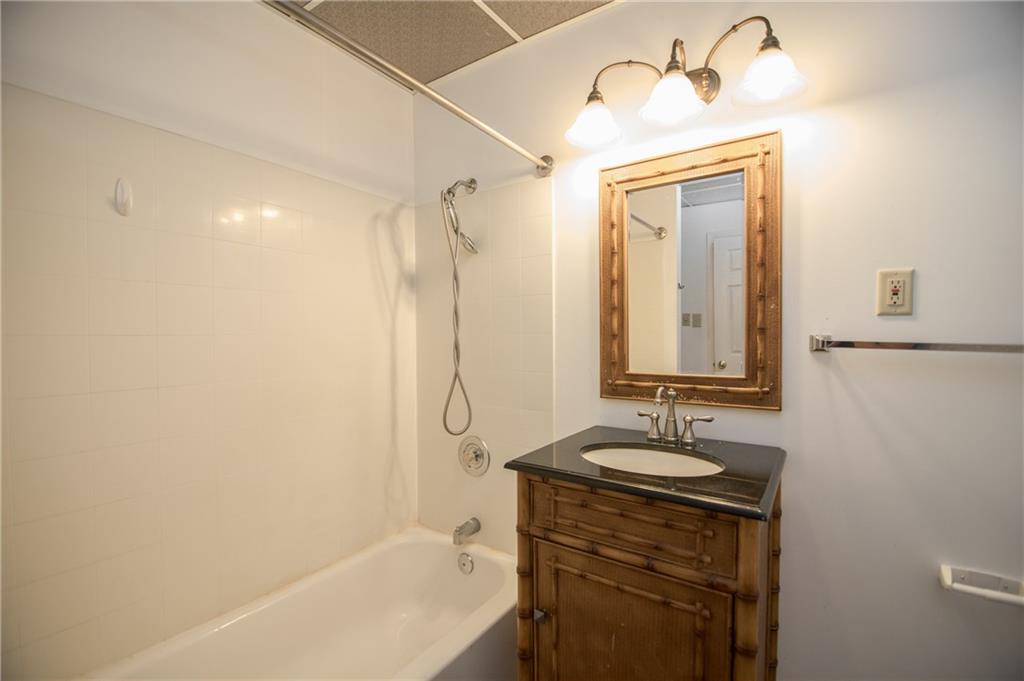 755 Sheridan Ridge Court Alpharetta, GA 30022 - Photo 45 of 57 a bathroom with a granite countertop sink a mirror and a bathtub