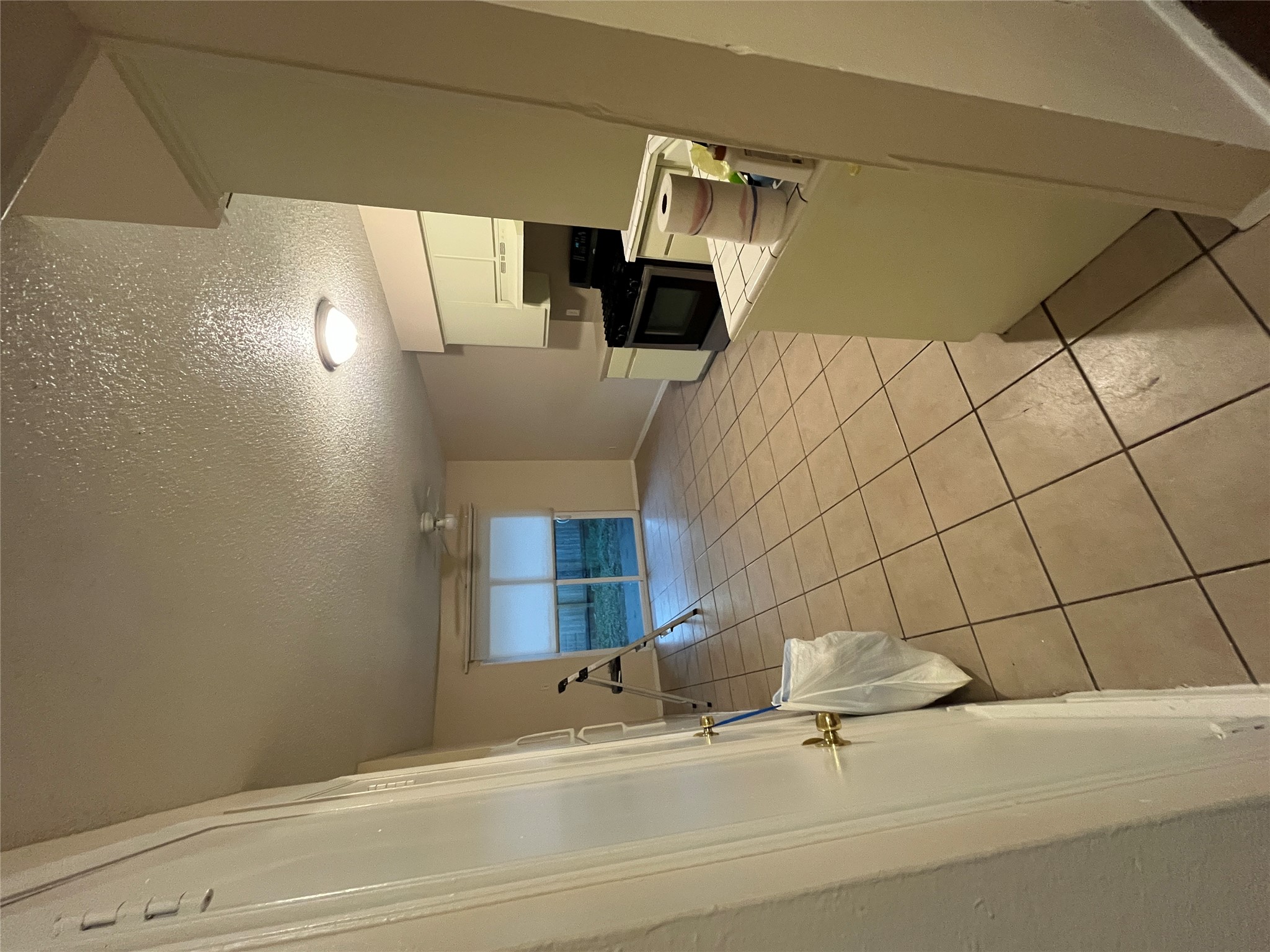 4702 Rocking Chair Road Austin, TX 78744 - Photo 23 of 28 Kitchen featuring white cabinets, range, light tile patterned floors, a ceiling fan, and a textured ceiling