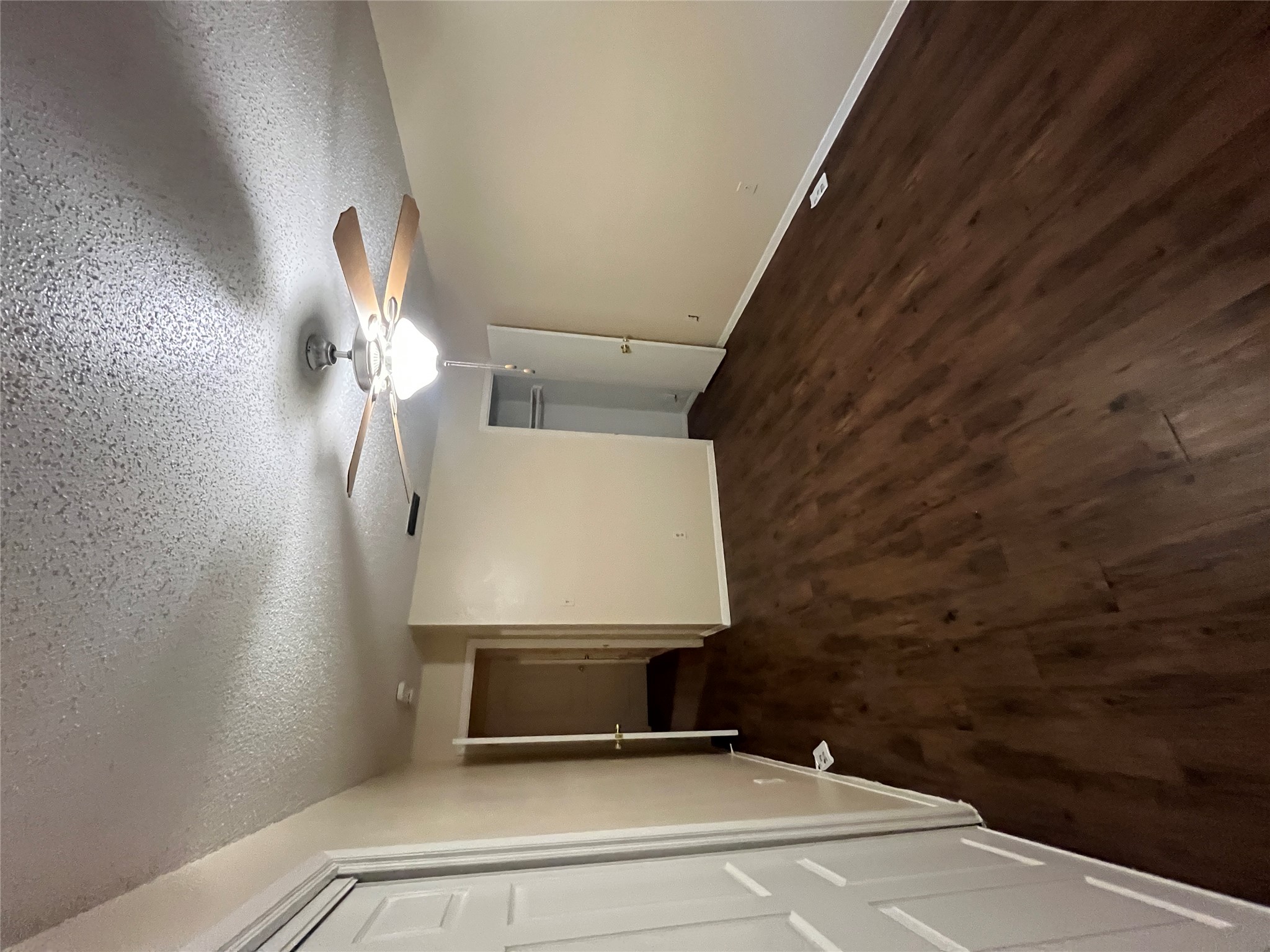 4702 Rocking Chair Road Austin, TX 78744 - Photo 27 of 28 Unfurnished bedroom featuring dark wood finished floors, a textured ceiling, and ceiling fan