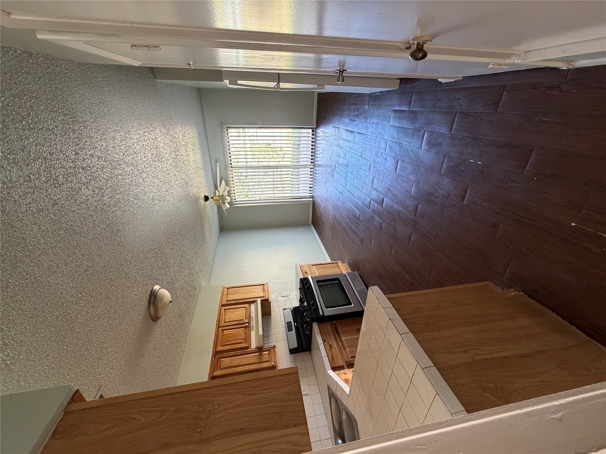 4702 Rocking Chair Road Austin, TX 78744 - Photo 6 of 28 Kitchen with tile countertops, dark wood-type flooring, ceiling fan, stainless steel gas range oven, and wood finish cabinets