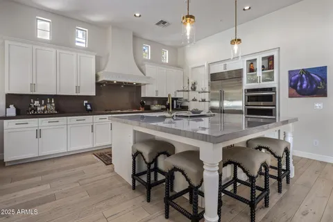 a kitchen with granite countertop white cabinets and chairs