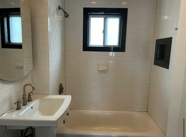 a white bath tub sitting next to a white sink