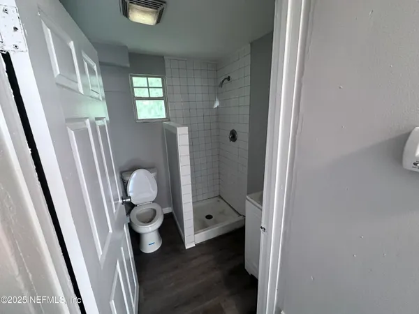 a bathroom with a toilet and a shower