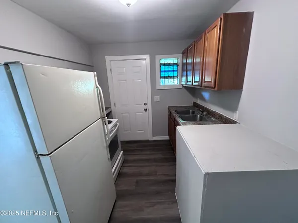 a kitchen with a refrigerator a stove and cabinets