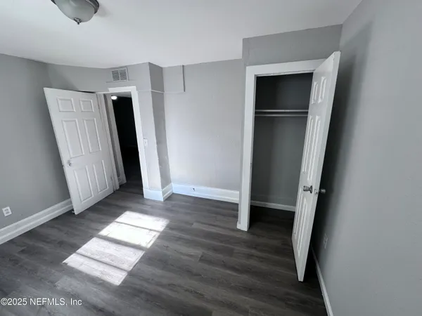 an entryway with wooden floor and a window