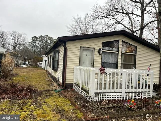 a view of a house with a small yard and wooden fence