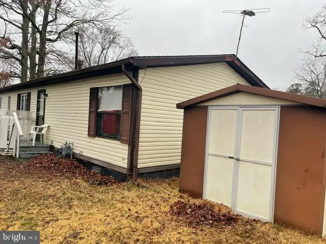 a backyard of a house with wooden fence and large trees