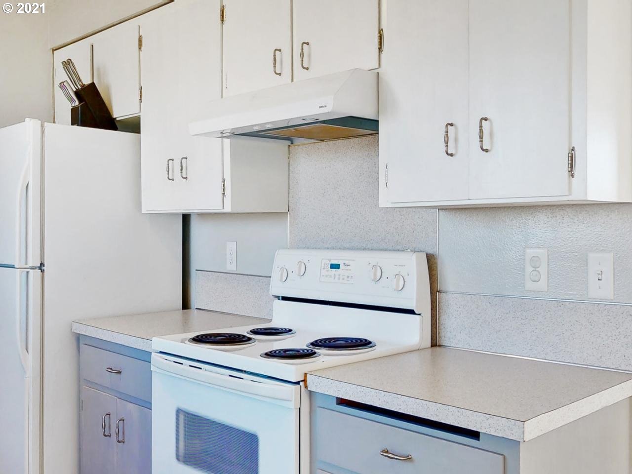 3440 C Street Springfield, OR 97478 - Photo 8 of 21 a kitchen with a stove and white cabinets