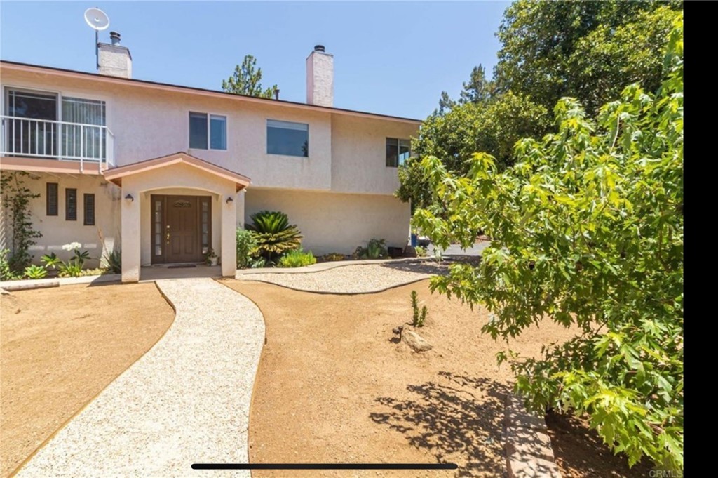 10210 Lilac Ridge Road Escondido, CA 92026 - Photo 2 of 26 a front view of a house with a yard and garage