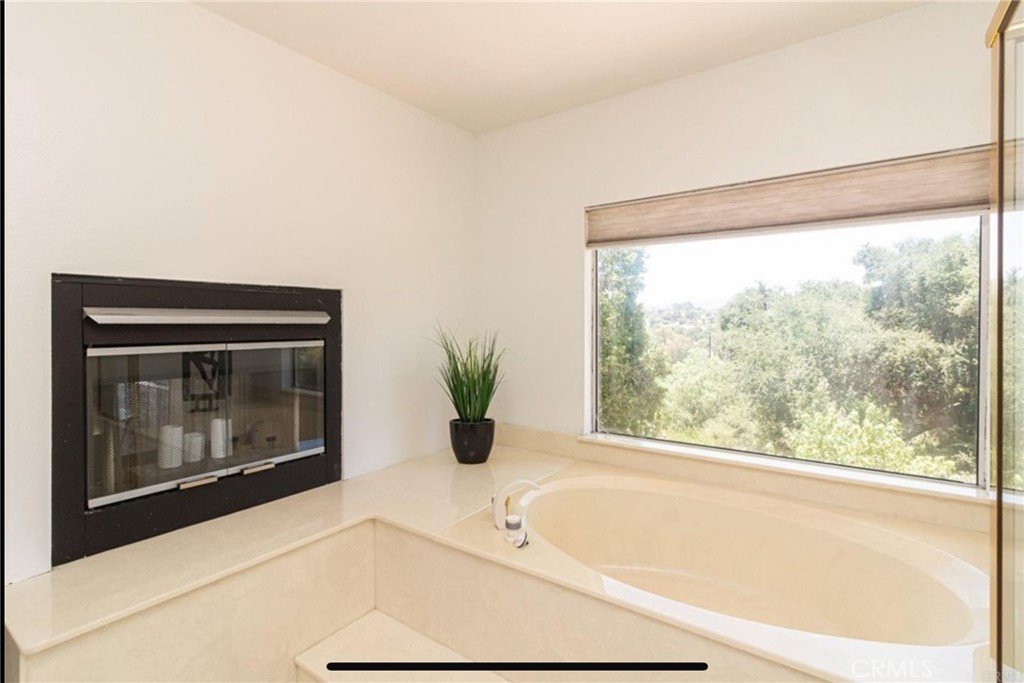 10210 Lilac Ridge Road Escondido, CA 92026 - Photo 22 of 26 a white bath tub sitting in a bathroom next to a window
