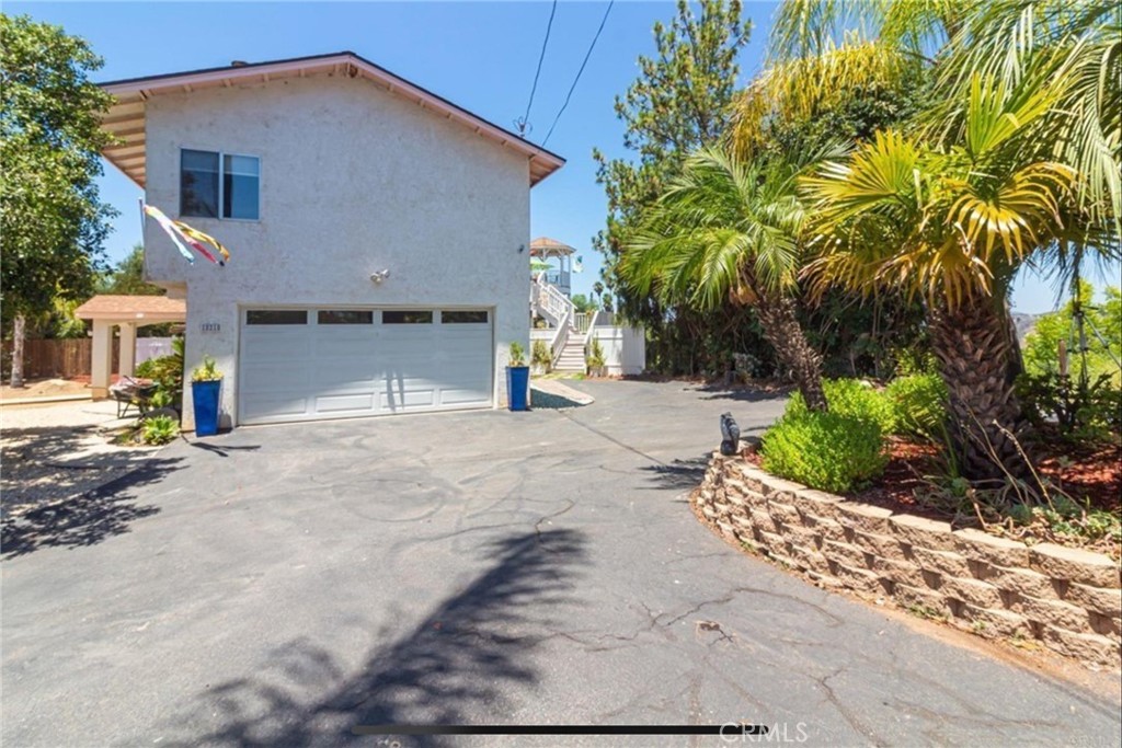 10210 Lilac Ridge Road Escondido, CA 92026 - Photo 3 of 26 a view of a house with a yard and garage