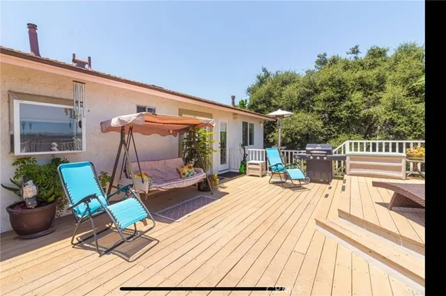 a view of a patio with a dining table and chairs with wooden floor and fence
