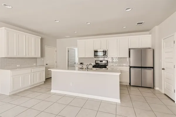 a kitchen with white cabinets a sink and white appliances