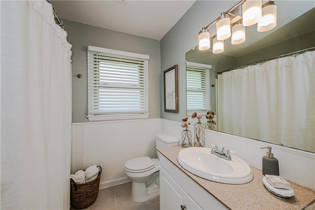 441 Scaleybark Road Charlotte, NC 28209 - Photo 16 of 24 a bathroom with a granite countertop sink toilet and mirror