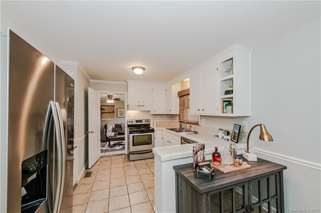 441 Scaleybark Road Charlotte, NC 28209 - Photo 7 of 24 a kitchen with stainless steel appliances a stove a refrigerator a sink a stove and white cabinets with wooden floor