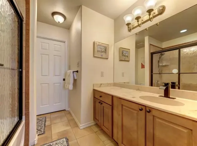 a bedroom with a bed and a lamp on the dresser