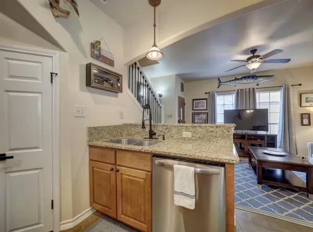 a kitchen with kitchen island granite countertop a sink stainless steel appliances and cabinets