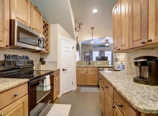 a kitchen with stainless steel appliances granite countertop a sink and a refrigerator