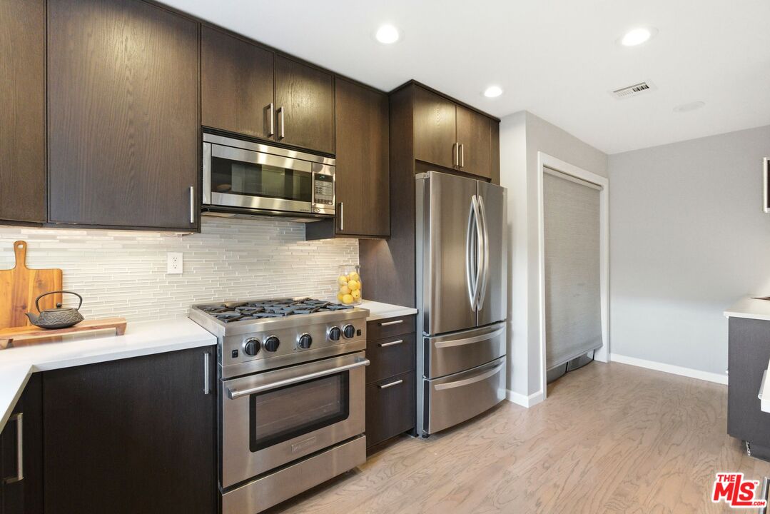 1013 16th Street, Unit 101 Santa Monica, CA 90403 - Photo 18 of 46 a kitchen with stainless steel appliances wooden cabinets and a stove