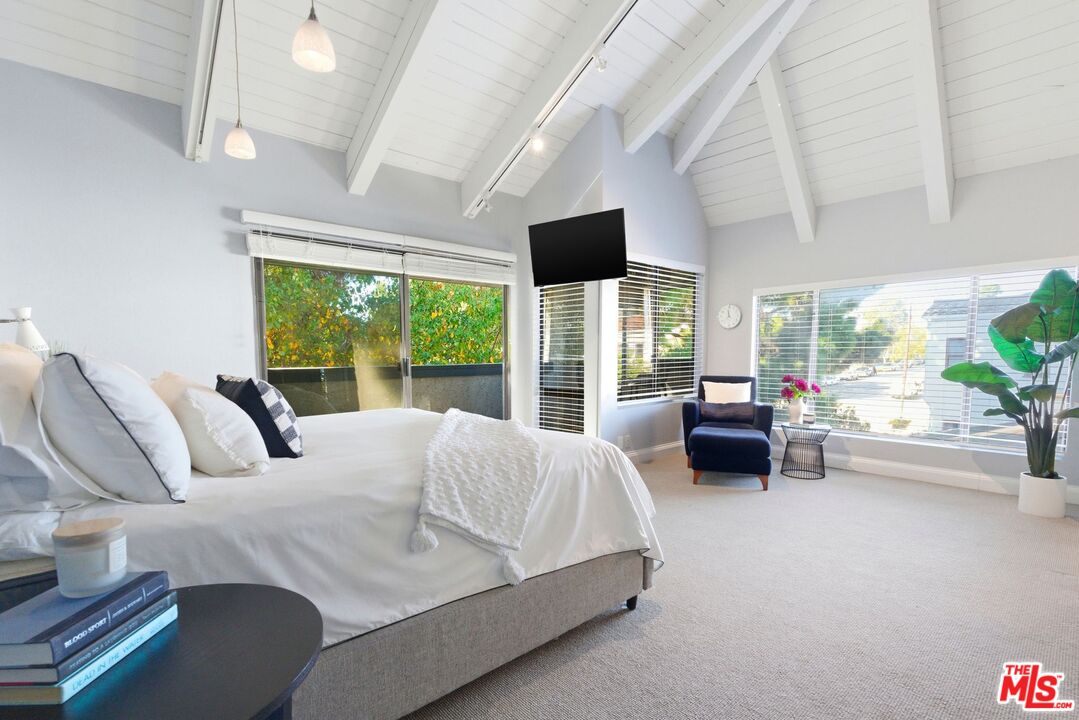 1013 16th Street, Unit 101 Santa Monica, CA 90403 - Photo 24 of 46 a bedroom with furniture a large window and a chandelier