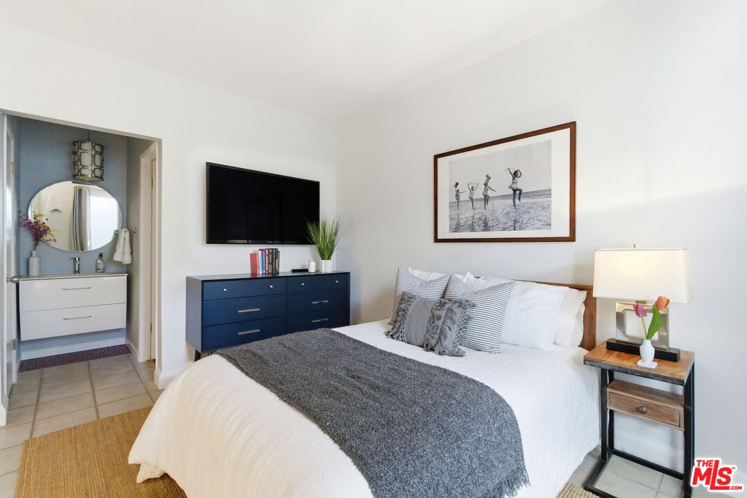 1013 16th Street, Unit 101 Santa Monica, CA 90403 - Photo 35 of 46 a bedroom with a bed and a flat screen tv