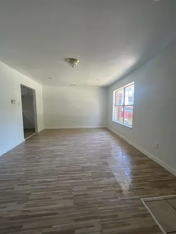 a kitchen with a wooden floor and white stainless steel appliances