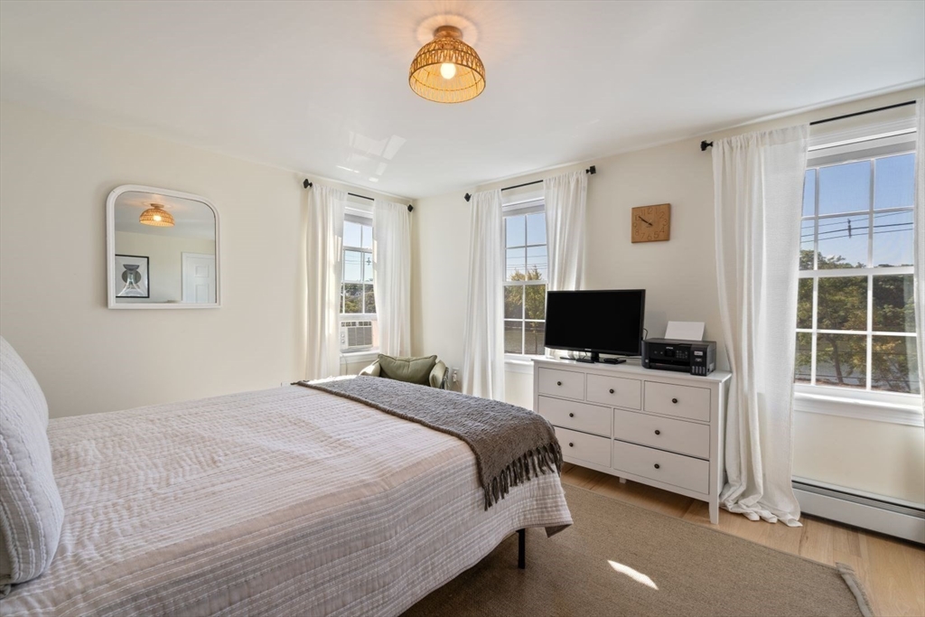31 Broad Cove Road Hingham, MA 02043 - Photo 16 of 22 a bedroom with a bed and flat tv screen on the dresser