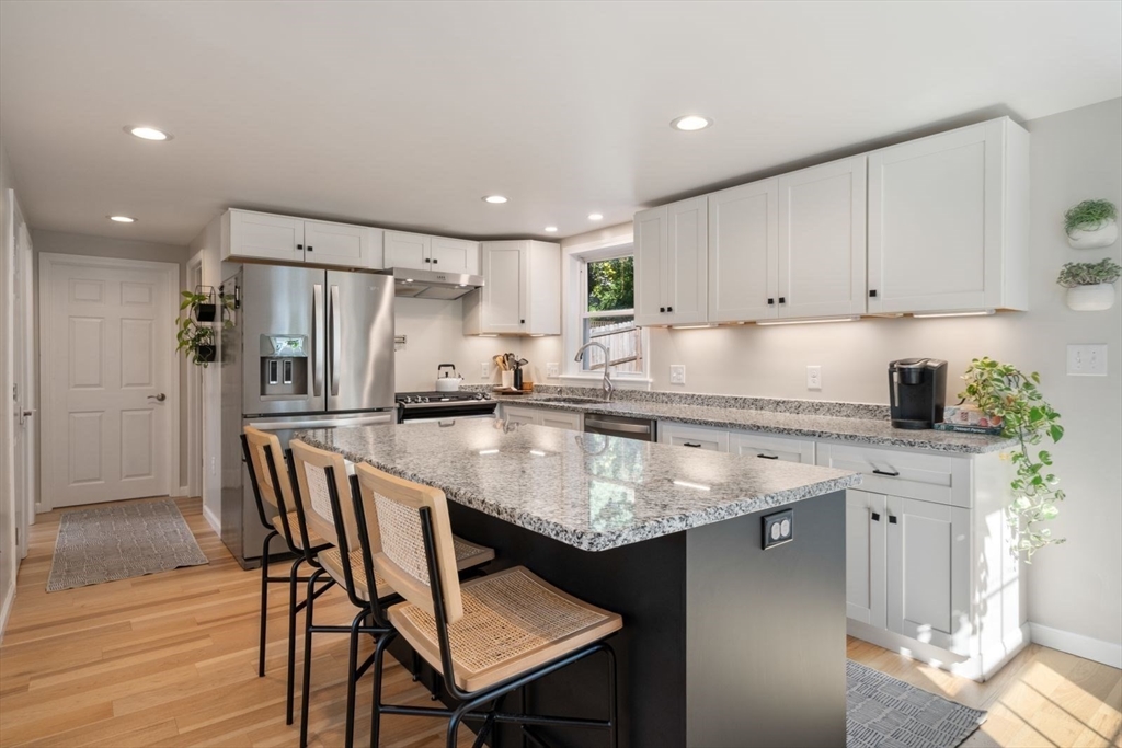 31 Broad Cove Road Hingham, MA 02043 - Photo 2 of 22 a kitchen with stainless steel appliances granite countertop a table chairs sink refrigerator and microwave