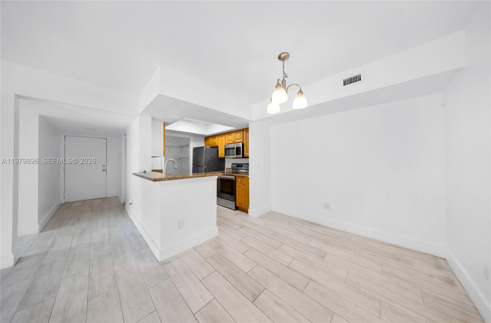 a view of a kitchen with wooden floor and electronic appliances