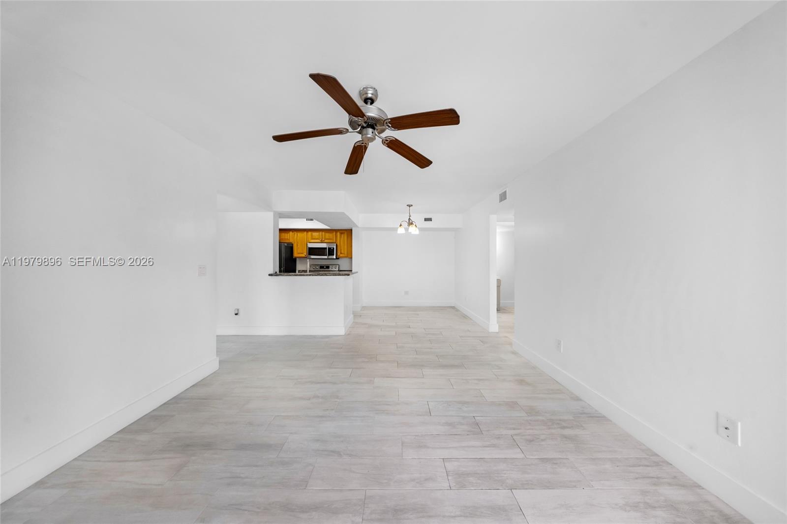 5760 Rock Island Road, Unit 321 Tamarac, FL 33319 - Photo 12 of 36 a view of a big room with wooden floor and a ceiling fan