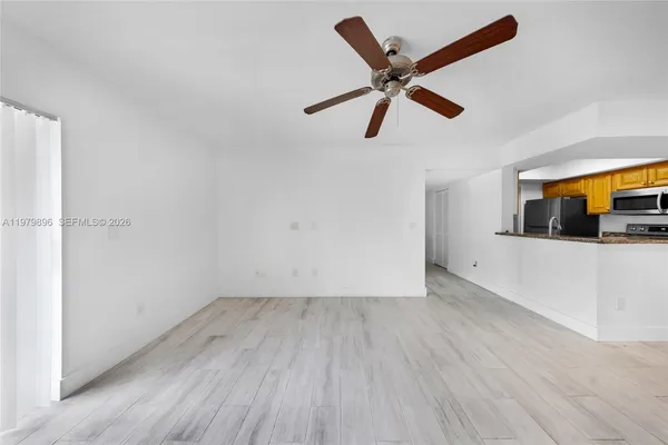 a view of a big room with wooden floor and windows