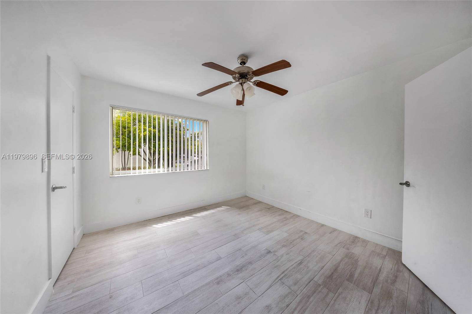 5760 Rock Island Road, Unit 321 Tamarac, FL 33319 - Photo 16 of 36 an empty room with wooden floor ceiling fan and windows