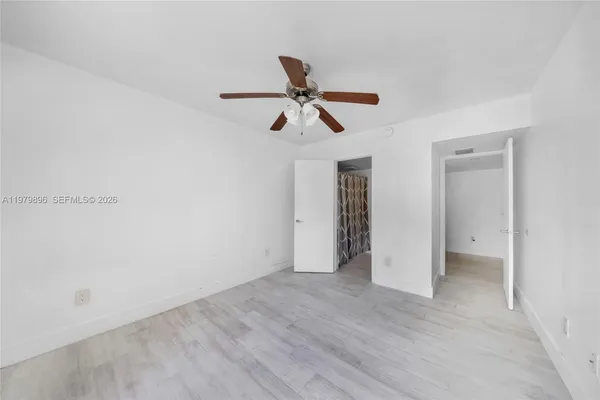 a view of a room with wooden floor and ceiling fan