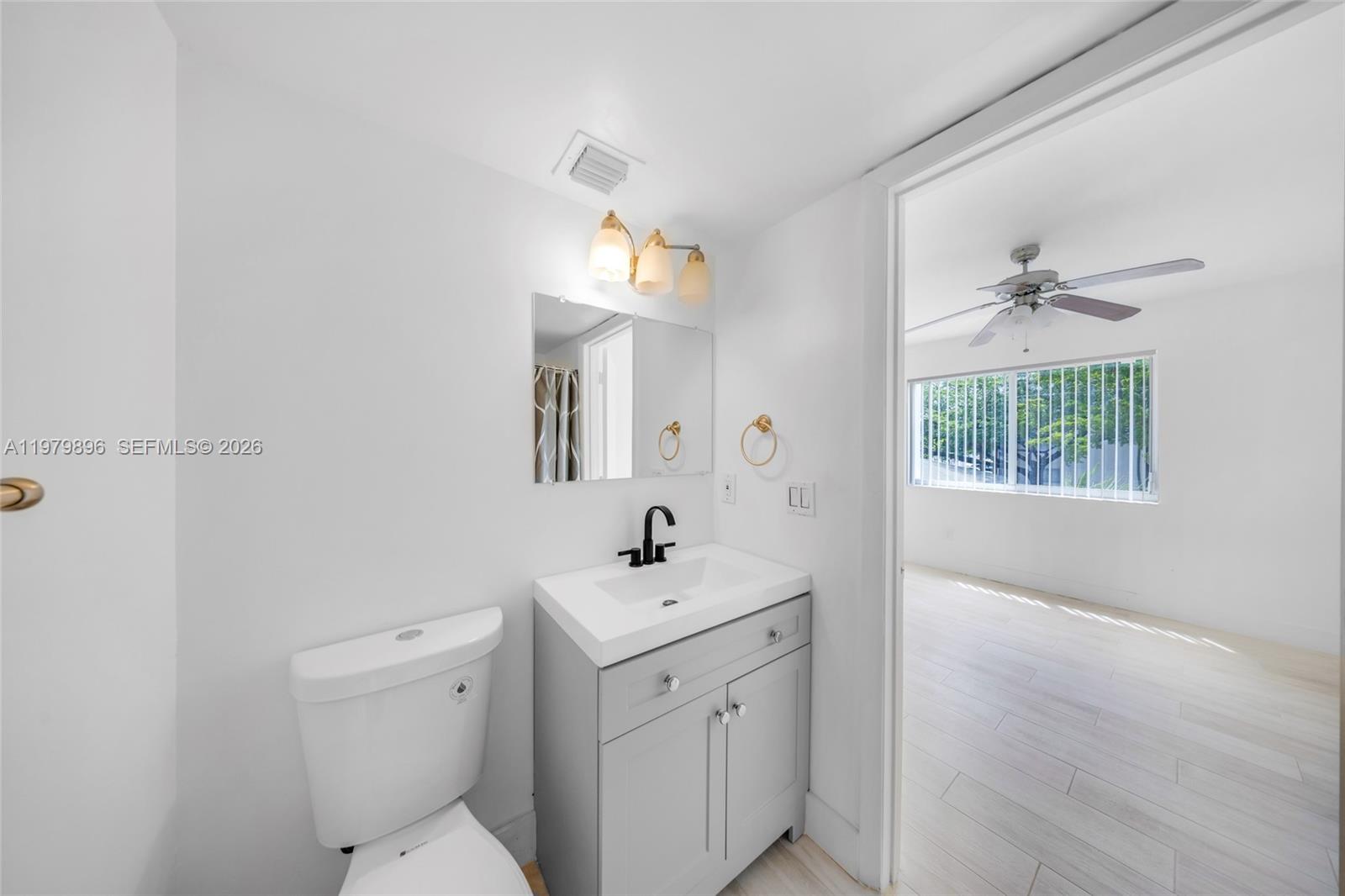5760 Rock Island Road, Unit 321 Tamarac, FL 33319 - Photo 20 of 36 a bathroom with a sink a mirror and a toilet