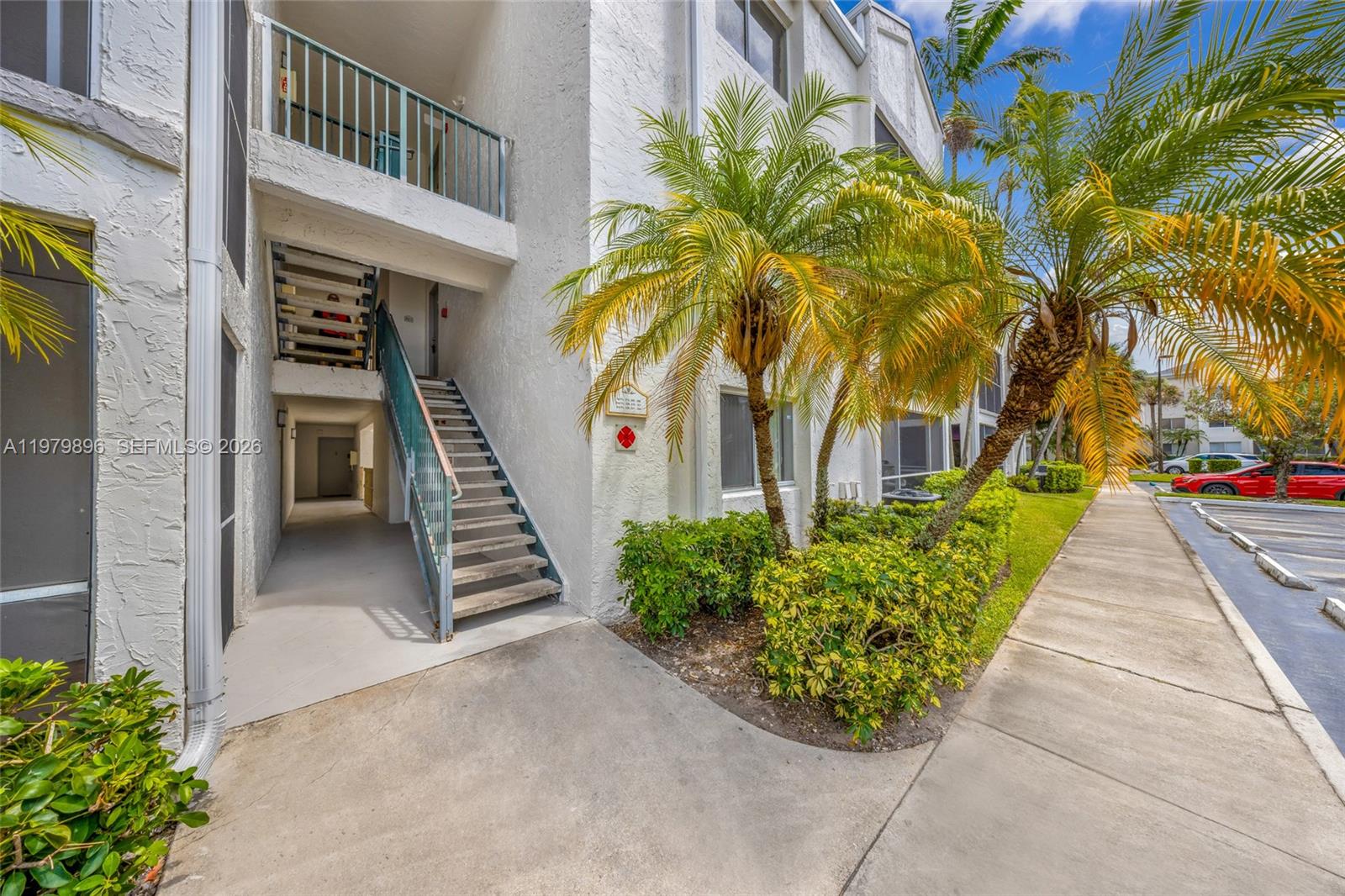 5760 Rock Island Road, Unit 321 Tamarac, FL 33319 - Photo 2 of 36 a front view of a house with a garden