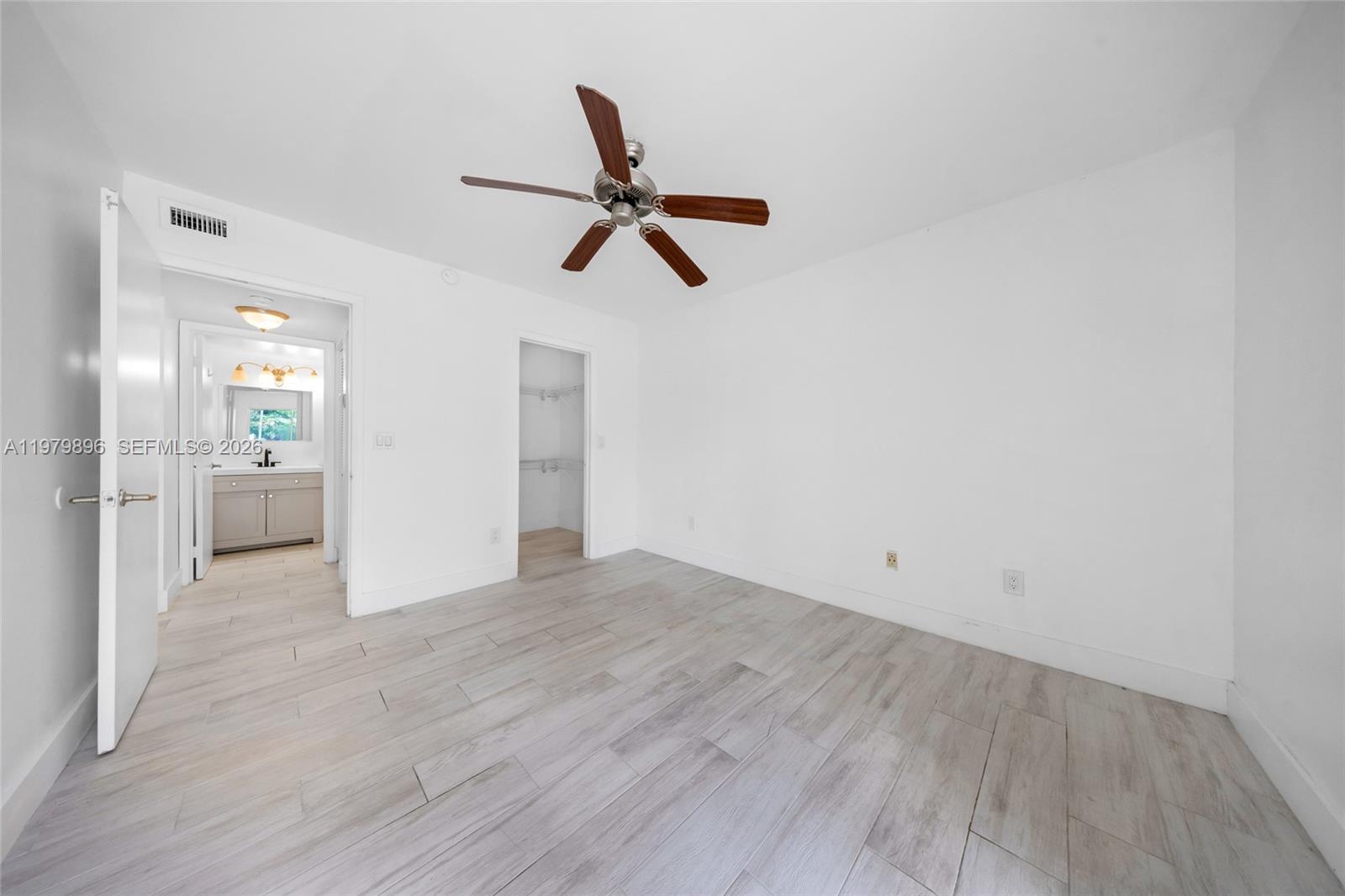 5760 Rock Island Road, Unit 321 Tamarac, FL 33319 - Photo 23 of 36 an empty room with wooden floor and windows