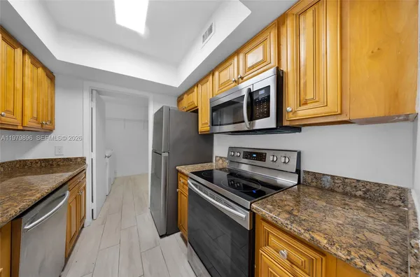 a kitchen with stainless steel appliances granite countertop a stove a sink and a microwave