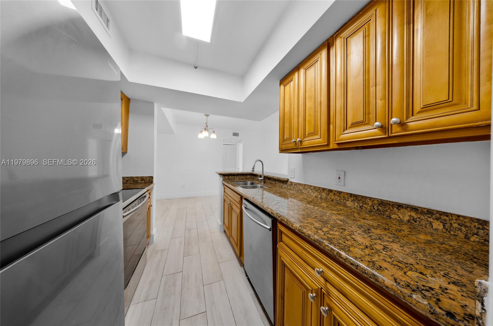 5760 Rock Island Road, Unit 321 Tamarac, FL 33319 - Photo 7 of 36 a kitchen with granite countertop stainless steel appliances a sink and cabinets