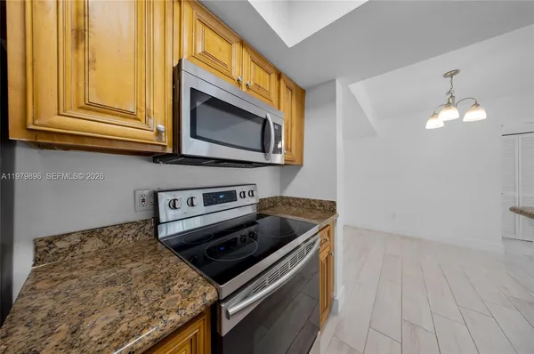 a kitchen with granite countertop a stove and a microwave