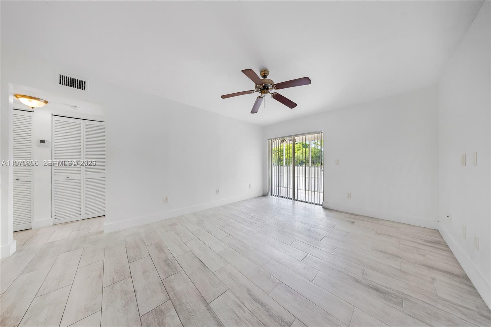 5760 Rock Island Road, Unit 321 Tamarac, FL 33319 - Photo 10 of 36 wooden floor in an empty room with a window