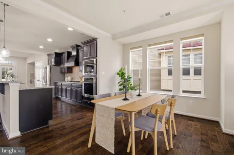 a living room with furniture a table and kitchen view