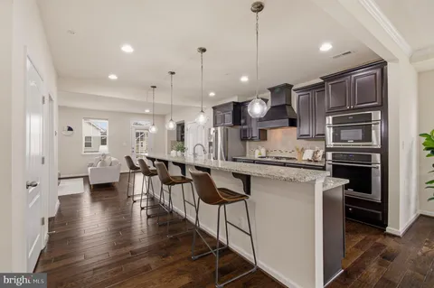 a kitchen with granite countertop a stove microwave and sink