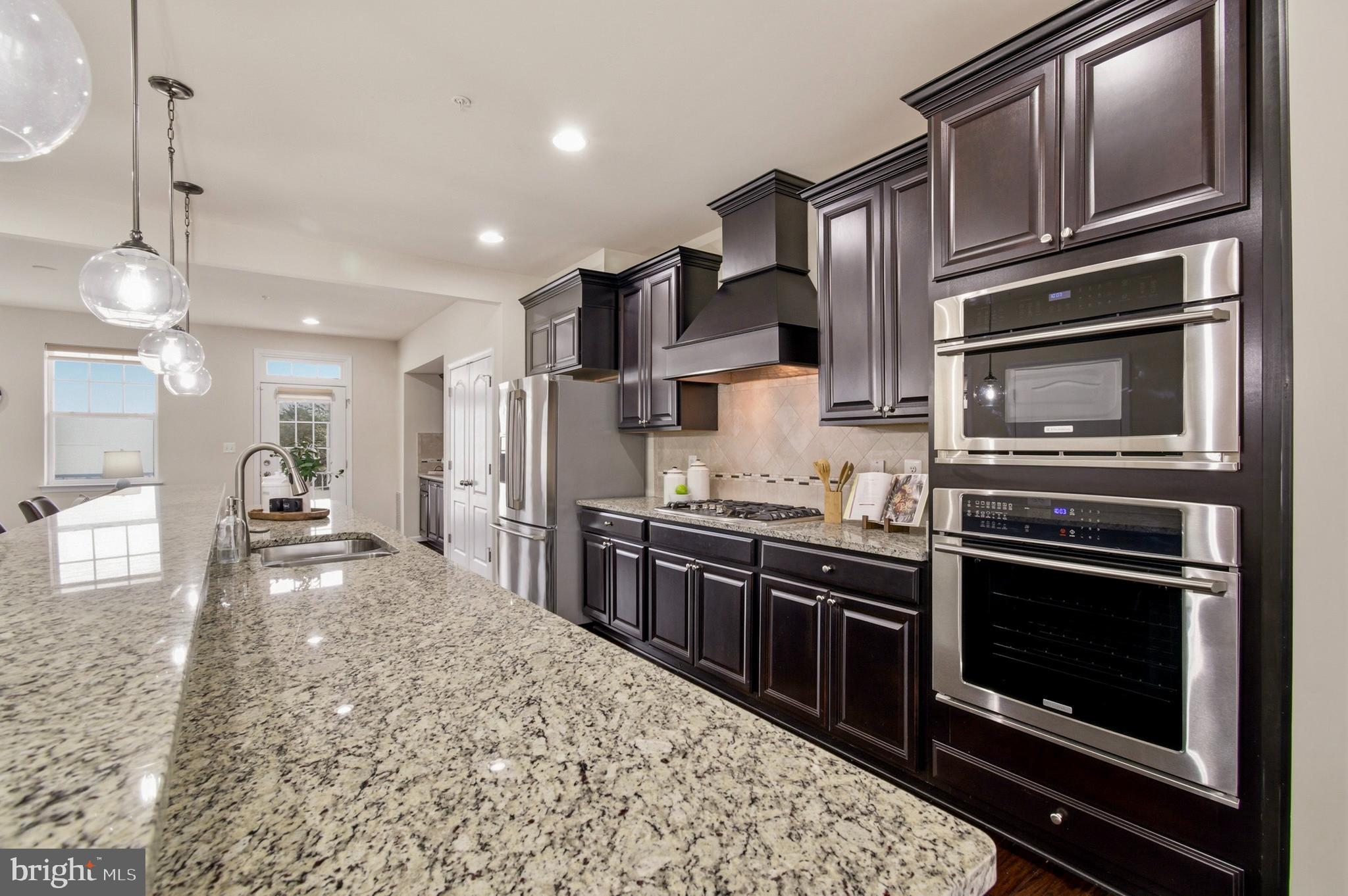 7015 Starwort Way, Unit A Hanover, MD 21076 - Photo 17 of 69 a kitchen with stainless steel appliances granite countertop a stove microwave and cabinets