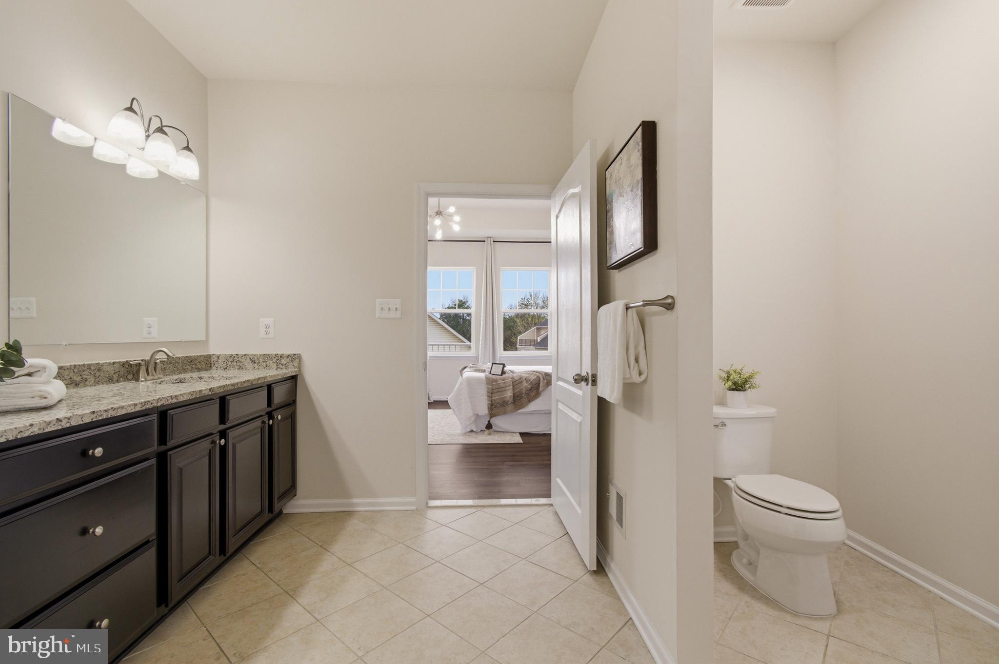 7015 Starwort Way, Unit A Hanover, MD 21076 - Photo 43 of 69 a spacious bathroom with a granite countertop toilet a sink and a mirror
