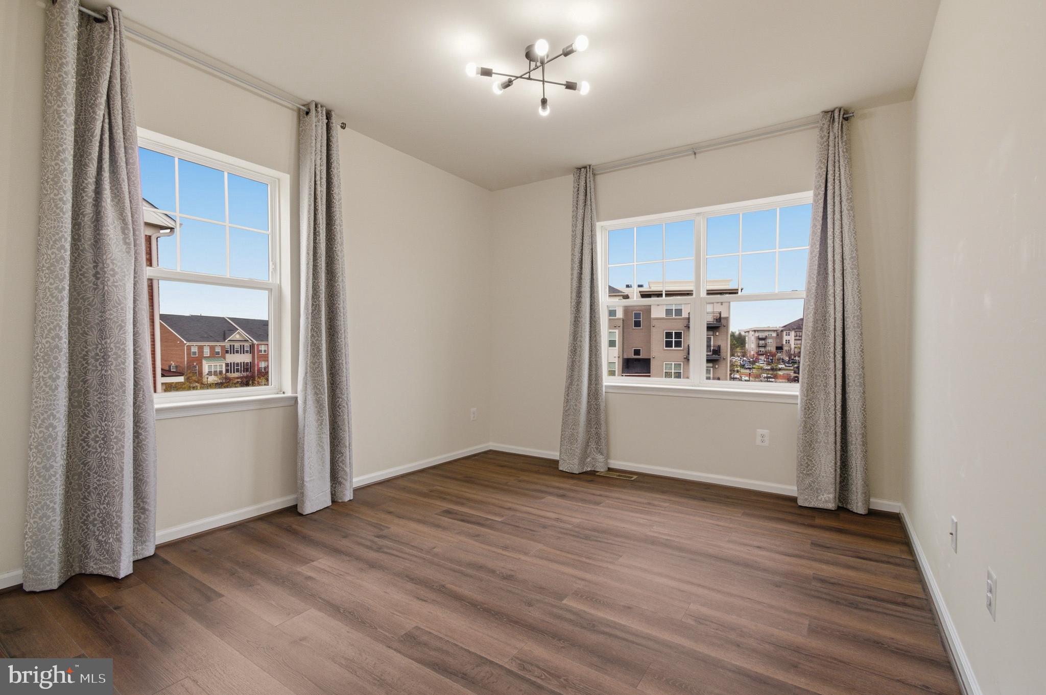 7015 Starwort Way, Unit A Hanover, MD 21076 - Photo 45 of 69 a view of an empty room with wooden floor and a window