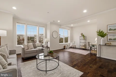 a living room with furniture wooden floor and a large window