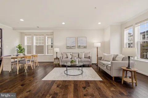 a living room with furniture wooden floor and large window