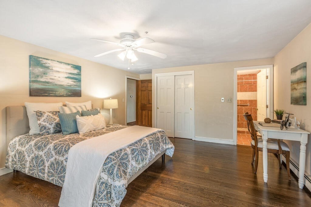 20 Argilla Road Ipswich, MA 01938 - Photo 19 of 33 a bedroom with a large bed and a chandelier