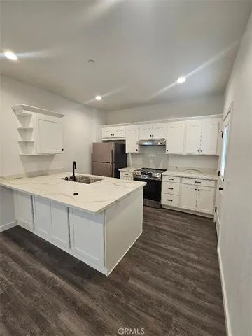 a kitchen with a sink a stove and cabinets